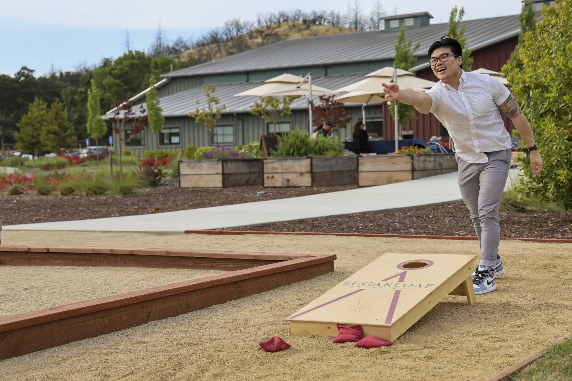 man playing corn hole at Sugarloaf Wine Co., best wineries in Sonoma County with corn hole